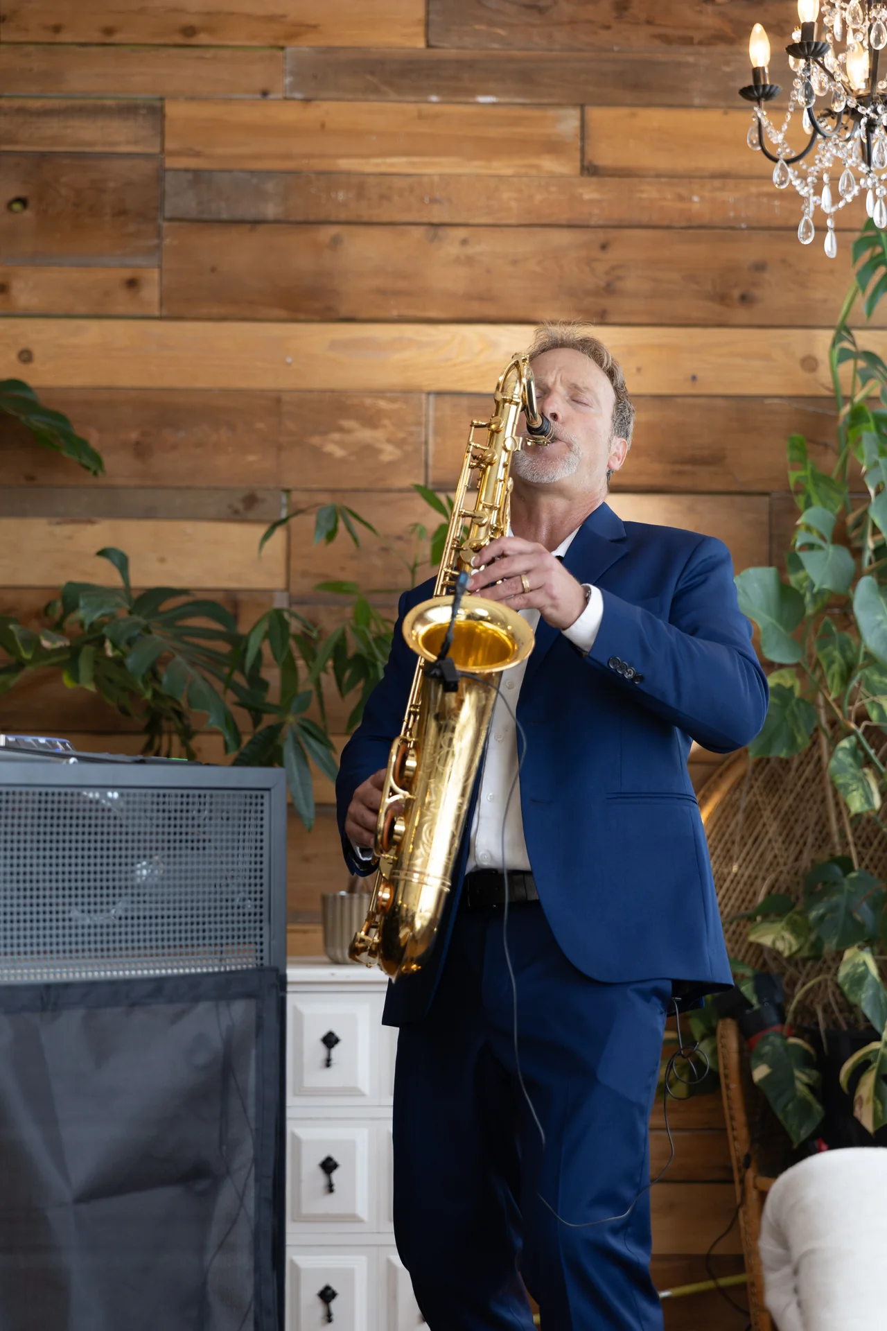 Howard Anderson performing saxophone in a blue suit